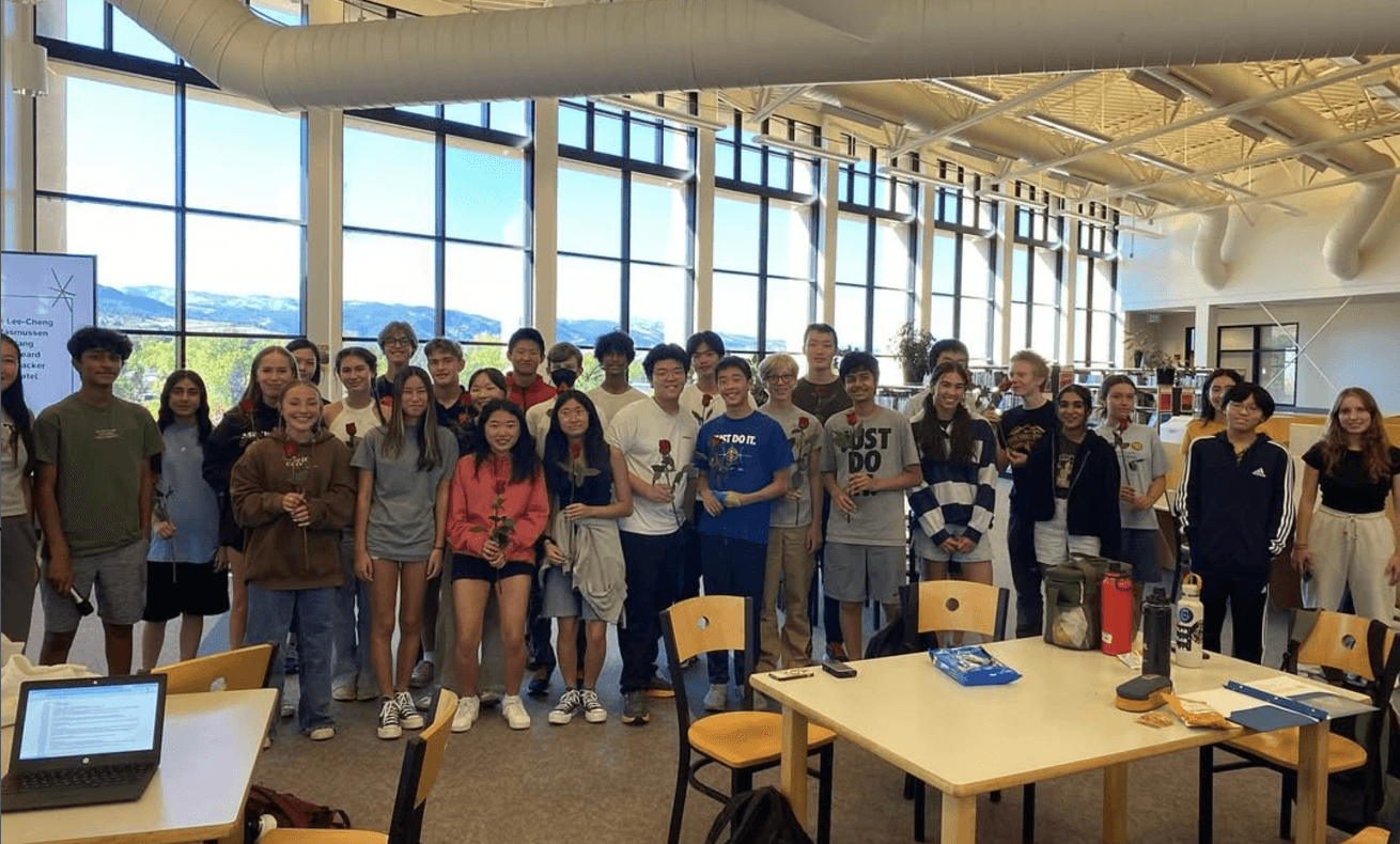 Fairview Mu Alpha Theta members gathered in the school library, many holding roses